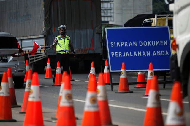 Polisi mengatur lalu lintas kendaraan saat penyekatan di jalan Tol Jakarta-Cikampek, Cikarang, Kabupaten Bekasi, Jawa Barat, Kamis (6/5).  Foto: Willy Kurniawan/REUTERS