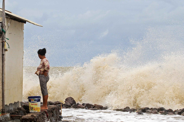 Warga melihat kondisi rumahnya yang diterjang ombak di desa Eretan Kulon, Kandanghaur, Kabupaten Indramayu, Jawa Barat. Foto: Dedhez Anggara/ANTARA FOTO