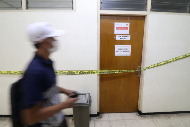 Seorang pria melintas di depan ruangan yang disegel Komisi Pemberantasan Korupsi (KPK) di gedung Badan Kepegawaian Daerah (BKD) Nganjuk, Jawa Timur, Senin (10/5).  Foto: Prasetia Fauzani/ANTARA FOTO