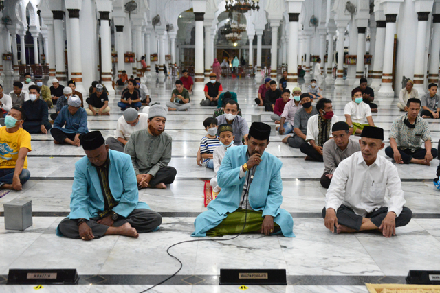 Umat muslim menggelar malam takbiran Idul Fitri dengan penerapan protokol kesehatan di Masjid Raya Baiturrahman Banda Aceh, Rabu (12/5/2021). Foto: Ampelsa/Antara