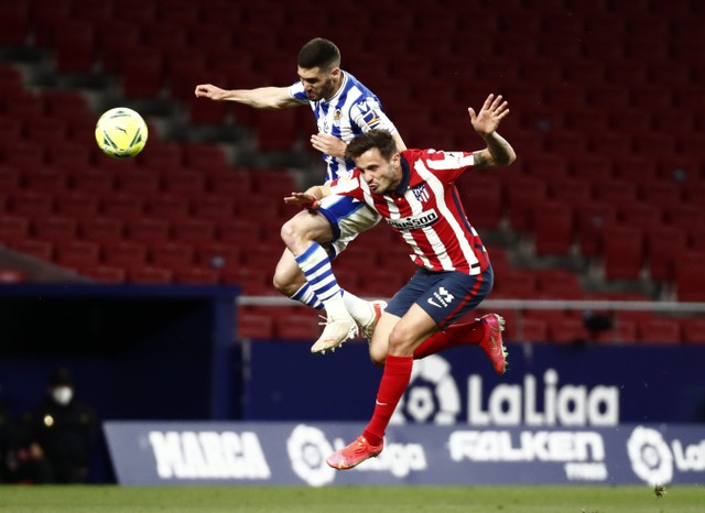 Pemain Atletico Madrid, Saul Niguez berduel dengan Joseba Zaldua dari Real Sociedad. Foto: REUTERS / Sergio Perez