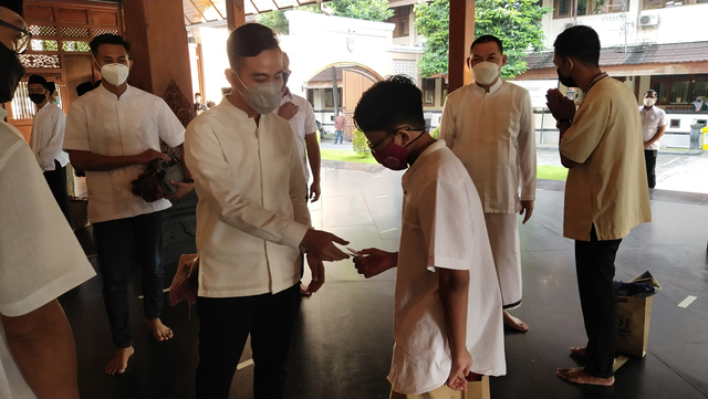 Gibran Rakabuming membagikan uang lebaran kepada anak-anak usai menjalankan Salat Idul Fitri di Balai Kota Solo.