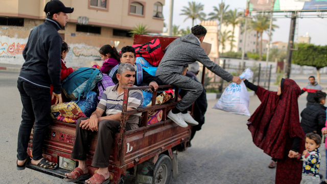 Warga Palestina yang mengendarai becak otomatis saat meninggalkan rumah mereka selama serangan udara dan artileri Israel, di Jalur Gaza utara, Jumat (14/5). Foto: Mohammed Salem/REUTERS
