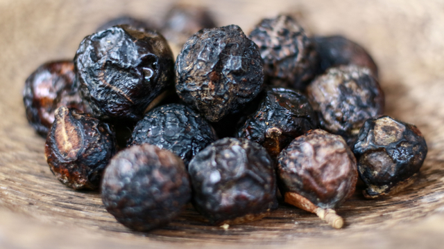 Sapindus rarak (lerak) di atas piring kayu. Foto: Shutter Stock