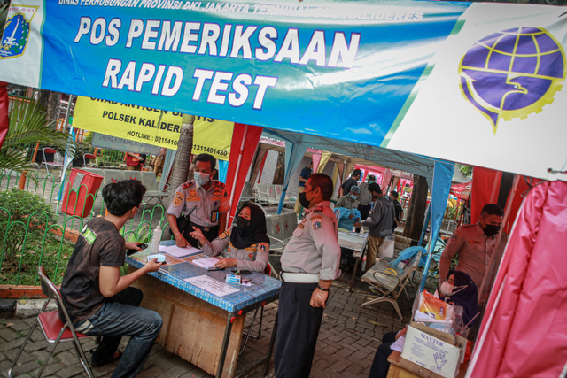 Petugas mendata pemudik sebelum mengikuti tes cepat antigen setibanya di Terminal Bus Kalideres, Jakarta, Senin (17/5). Foto: Fauzan/ANTARA FOTO