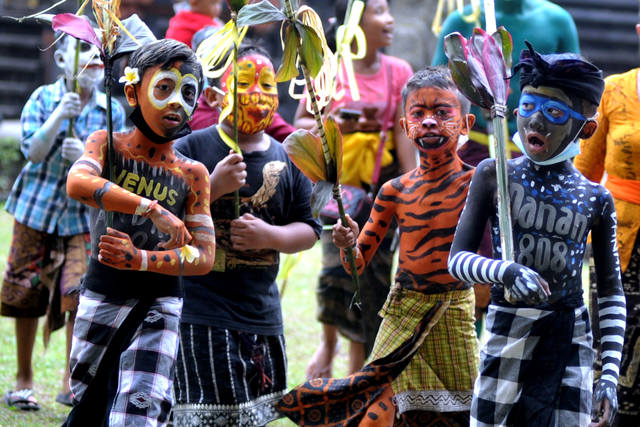 Sejumlah anak yang memakai riasan warna-warni berkeliling kampung saat ritual Ngerebeg di Desa Tegallalang, Gianyar, Bali, Rabu (19/5/2021). Foto: Fikri Yusuf/Antara Foto