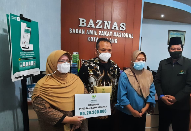 Kepala Baznas Kota Malang, Sulaiman memberikan bantuan dana pelunasan secara simbolis kepada guru TK korban pinjol, Jumat (21/5/2021). Foto/Azmy