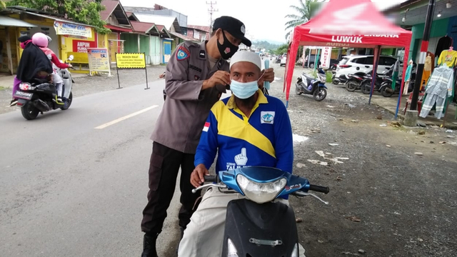 Jajaran Polsek Toili saat membagikan masker kepada pengendaran di Jalan Trans Sulawesi di Desa Tirtakencana Kecamatan Toili, Kabupaten Banggai, tepatnya di depan Pos Pengamanan Lebaran 2021 Polsek Toili, Sabtu (22/5) pagi. Foto: Istimewa