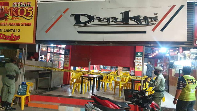 Petugas gabungan menyegel warung kopi di Kota Banda Aceh karena masih buka pukul 23.00 WIB, pada Sabtu (22/5) malam. Foto: Dok. Polda Aceh