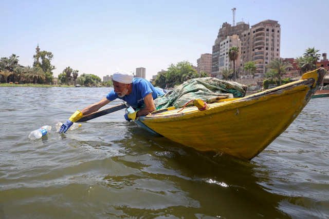 Mohamed Nasar, menggunakan kapalnya mengumpulkan sampah plastik dari sungai Nil di Giza, Mesir. Foto: Mohamed Abd El Ghany/REUTERS