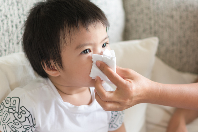 Ilustrasi orang tua membantu anak balita mengeluarkan ingus saat pilek. Foto: Shutterstock
