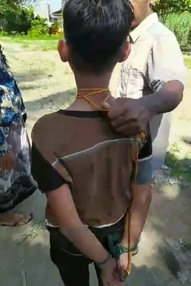 Tangkapan layar video tangan dan leher seorang anak di Aceh Utara dijerat dengan tali karena diduga mencuri celengan masjid yang beredar luas di media sosial. 
