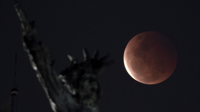 Fase gerhana bulan total terlihat dengan latar depan tugu pembebasan Irian Barat di Lapangan Banteng, Jakarta, Rabu (26/5/2021). Foto: Wahyu Putro A/ANTARA FOTO