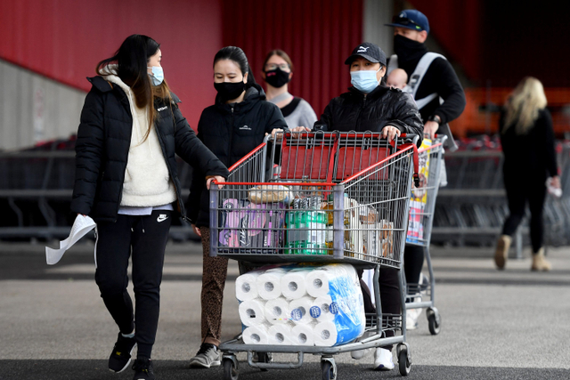 Warga membawa troli usai belanja di supermarket saat Melbourne kembali lockdown, Kamis (27/5).  Foto: WILLIAM WEST / AFP