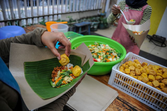 Pekerja memasak untuk kebutuhan gerakan nasi bungkus dua ribu di Jalan Natuna, Bandung, Jawa Barat, Kamis (27/5). Foto: Raisan Al Farisi/ANTARA FOTO