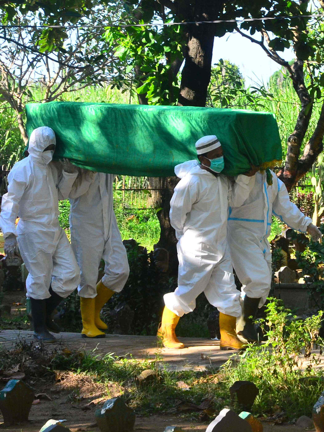Tim Gugus Tugas Pencegahan dan Pengendalian COVID-19 mengusung jenazah pasien corona di TPU Desa Bakalankrapyak, Kudus, Jawa Tengah, Kamis (27/5/2021). Foto: Yusuf Nugroho/Antara Foto