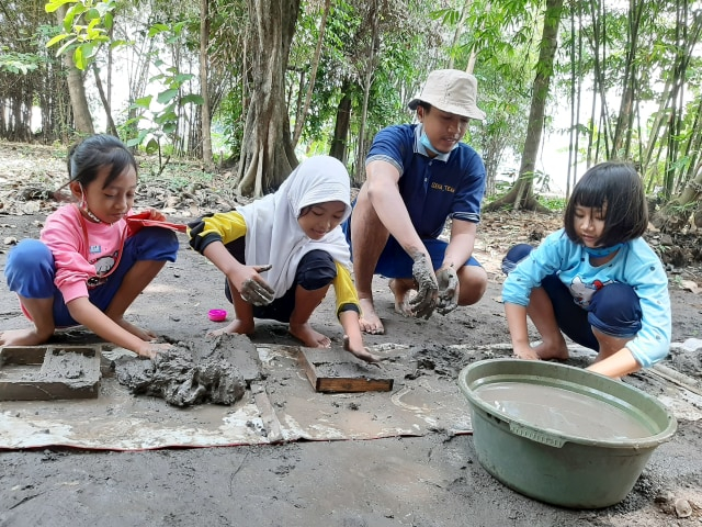 Irfan bersama anak-anak melakukan kegiatan membuat batu bata di Kampung Lali Gadget. Foto-foto: Amanah Nur Asiah/Basra