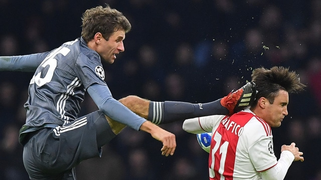 Thomas Mueller menendang kepala Nicolas Tagliafico. (Foto: AFP/Emmanuel Dunand)