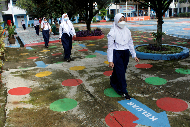Sejumlah siswa berjalan dengan mengatur jarak saat uji coba pembelajaran tatap muka di SMP N 15 Kota Bogor, Jawa Barat, Senin (31/5).  Foto: Arif Firmansyah/ANTARA FOTO