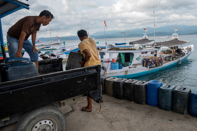 Pekerja menurunkan BBM jenis solar ke kapal nelayan di Pelabuhan Pendaratan Ikan (PPI) Donggala, Sulawesi Tengah, Selasa (1/6/2021). Foto: Basri Marzuki/Antara Foto