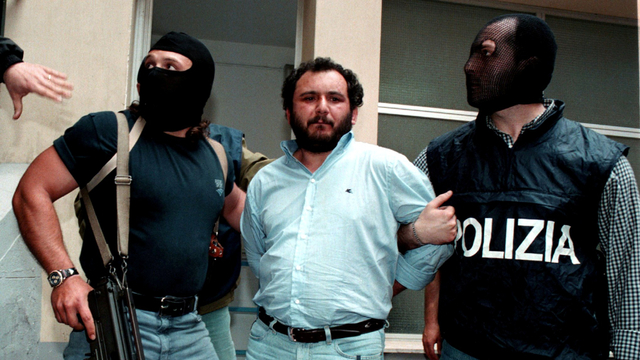 Polisi anti-Mafia mengawal buronan Mafia Giovani Brusca saat ia meninggalkan markas polisi Palermo untuk dibawa ke penjara. Foto: Reuters