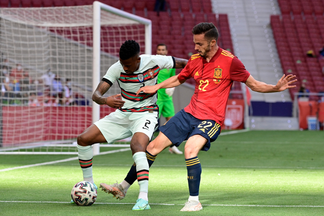 Pemain Timnas Portugal Nelson Semedo berebut bola dengan pemain Timnas Spanyol Pablo Sarabia pada pertandingan persahabatan di stadion Wanda Metropolitano, Madrid, Spanyol. Foto: JAVIER SORIANO / AFP