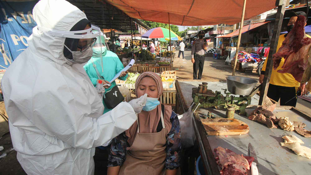 Petugas kesehatan melakukan tes usap PCR COVID-19 kepada pedagang di pasar tradisional, Jalan Indrakila, Surabaya, Jawa Timur, Sabtu (5/6/2021). Foto: Didik Suhartono/ANTARA FOTO
