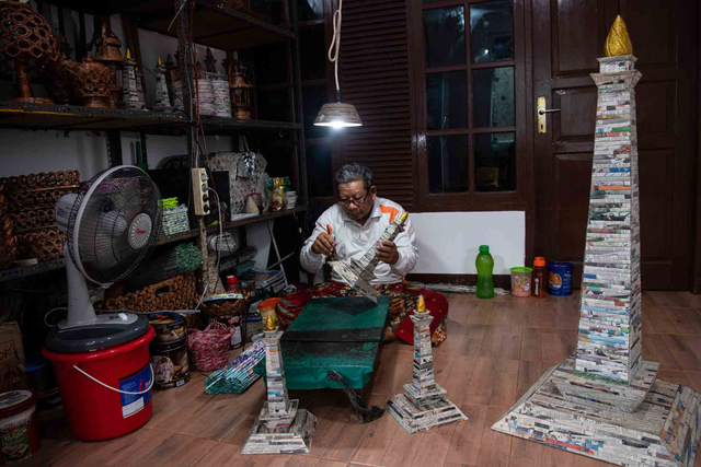 Sugito (86) menyelesaikan pembuatan miniatur Monas dari kertas koran bekas di Bank Sampah Tri Alam Lestari, Pesanggrahan, Jakarta Selatan, Sabtu (5/6/2021). Foto: Sigid Kurniawan/ANTARA FOTO