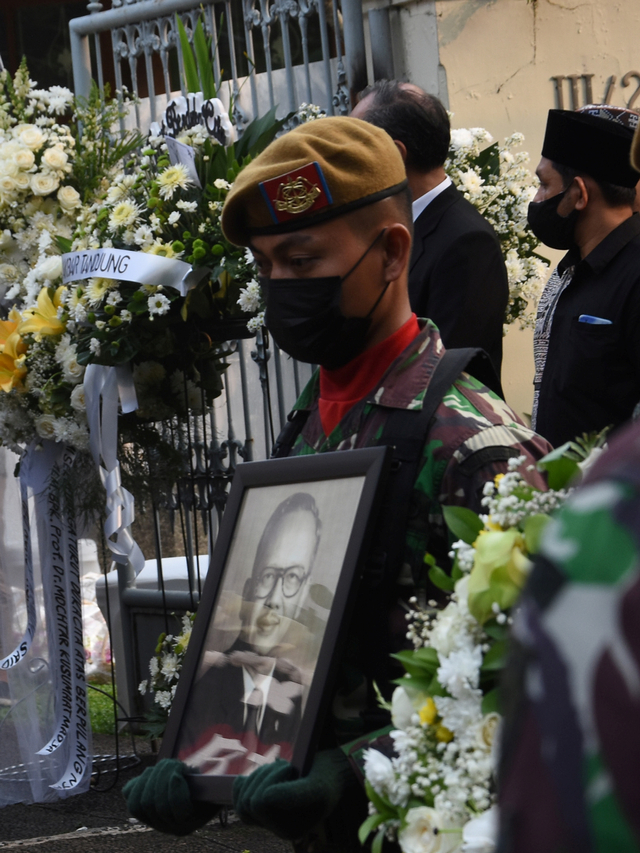 Seorang anggota TNI membawa foto dari Almarhum mantan Menteri Luar Negeri Mochtar Kusumaatmadja di rumah duka di kawasan Kebayoran Baru, Jakarta, Minggu (6/6/2021). Foto: Indrianto Eko Suwarso/Antara Foto