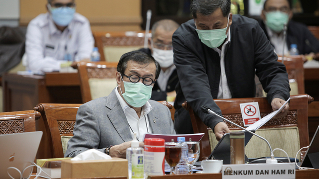 Menteri Hukum dan HAM Yasonna H. Laoly (kiri) bersiap mengikuti rapat kerja dengan Komisi III DPR di Kompleks Parlemen, Senayan, Jakarta, Rabu (9/6/2021).  Foto: ANTARA FOTO/Dhemas Reviyanto