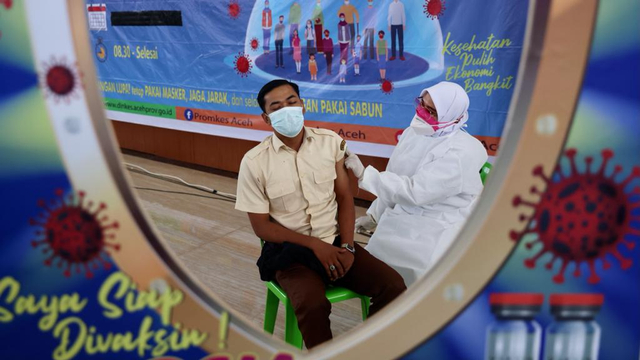 Seorang tenaga kontrak di lingkungan Pemerintah Aceh menjalani vaksinasi COVID-19 di Banda Aceh Convention Hall, Selasa (8/6/2021). Foto: Suparta/acehkini