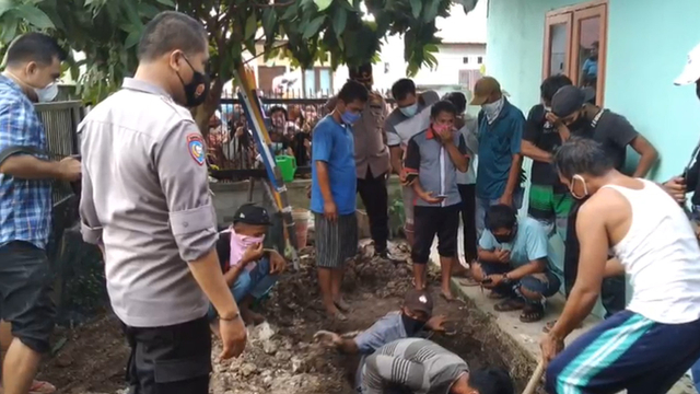 PROSES pembongkaran lubang septic tank oleh warga dan keluarga disaksikan anggota kepolisian almarhumah Siti Hamidah, Selasa (8/6/2021), di Perumahan Griya Sakti, Jalan Garuda Sakti KM 9, Karya Indah, Tapung, Kampar, Riau.  