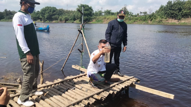 Camat Kasiman bersama Kepala Desa Tembeling, saat mengambil sampel air Sungai Bengawan Solo. Jumat (11//06/2021) (foto: dan/beritabojonegoro)