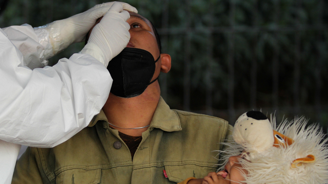 Petugas kesehatan melakukan tes Antigen kepada warga dari Pulau Madura saat penyekatan di akses keluar Jembatan Suramadu, Surabaya, Jawa Timur, Sabtu (12/6/2021). Foto: Didik Suhartono/ANTARA FOTO