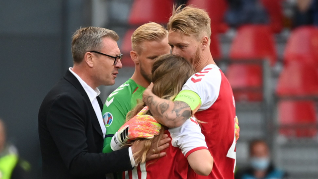 Simon Kjaer memeluk istri Christian Eriksen yang memasuki lapangan pertandingan. Foto: REUTERS/Hannah McKay