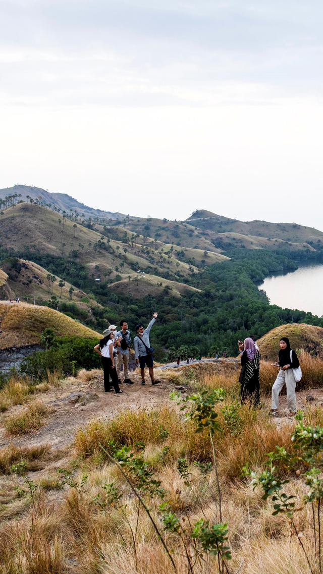 Wisatawan menikmati wisata Bukit Amelia, Labuan Bajo, Manggarai Barat, Nusa Tenggara Timur, Minggu (13/6/2021). Foto: Rivan Awal Lingga/ANTARA FOTO