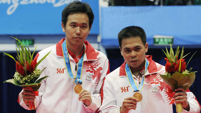 Markis Kido (kanan) dan Hendra Setiawan (kiri) dari Indonesia berpose dengan medali emas saat upacara penghargaan di Asian Games ke-16 di Guangzhou pada 20 November 2010. Foto: LIU JIN/AFP
