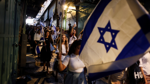 Warga Israel berjalan dengan bendera di sebuah gang di Kota Tua Yerusalem, Israel, Selasa (15/6). Foto: Ronen Zvulun/REUTERS