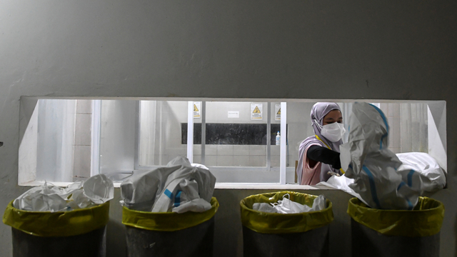 Seorang tenaga kesehatan membuang baju hazmat usai bertugas merawat pasien di RSDC Wisma Atlet Kemayoran, Jakarta, Selasa(15/6/2021). Foto: M Risyal Hidayat/ANTARA FOTO