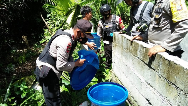 Anggota Polsek Toili, Polres Banggai saat mengamankan miras jenis cap tikus di Desa Sindang Baru, Kecamatan Toili, Kabupaten Banggai, Sulteng, Rabu (16/6). Foto: Istimewa