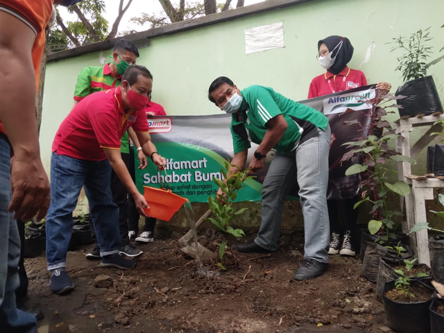 Corporate Communication Regional Manager PT Sumber Alfaria Trijaya (Alfamart), M Faruq Asrori (kiri), bersama Pembina Kader Lingkungan Kota Malang, Wasto (kanan), saat menanam bibit pohon di lingkungan Kantor Kecamatan Lowokwaru. Foto: Feni Yusnia