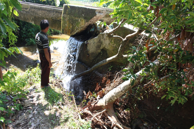 Salah seorang warga melihat kondisi rusaknya saluran irigasi di Desa Koto Panjang, Koto Nan Tigo Selatan, Kecamatan Sutera, Kabupaten Pesisir Selatan, Sumatera Barat. Foto: dok warga Sutera