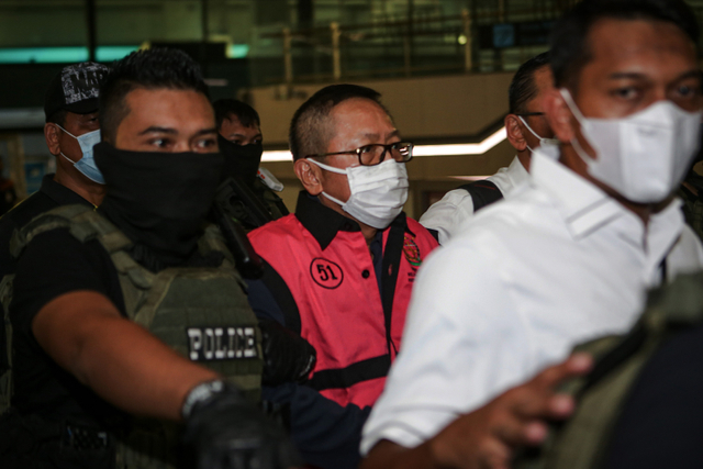 Terpidana kasus pembalakan liar Adelin Lis (tengah) dibawa oleh petugas setibanya di Bandara Soekarno Hatta, Tangerang, Banten, Sabtu (19/6).  Foto: Fauzan/ANTARA FOTO