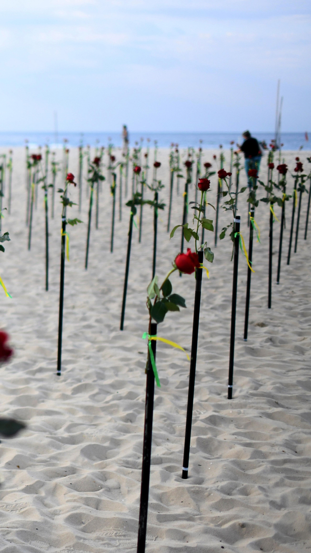 Sejumlah bunga merah yang ditempatkan di sepanjang pantai Copacabana di Rio de Janeiro, Brasil, Minggu (20/6). Foto: Lucas Landau/REUTERS