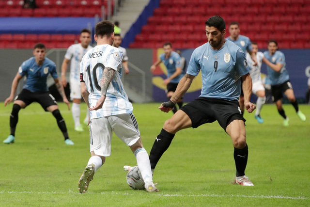 Aksi Lionel Messi saat melewati Luis Suarez ketka Argentina vs Uruguay, Sabtu (19/6). Foto: Henry Romero/REUTERS