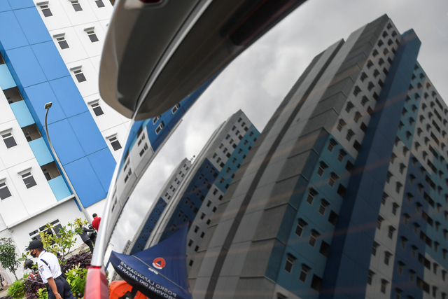 Petugas keamanan berjalan di Rumah Susun Nagrak, Cilincing, Jakarta Utara, Senin (21/6/2021). Foto: M Risyal Hidayat/Antara Foto