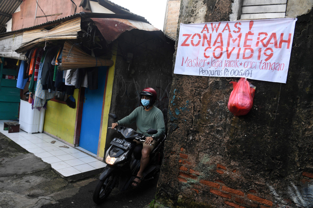 Warga berkendara di zona merah COVID-19 RT 006 RW 01, Gandaria Selatan, Cilandak, Jakarta Selatan, Senin (21/6/2021). Foto: Sigid Kurniawan/Antara Foto