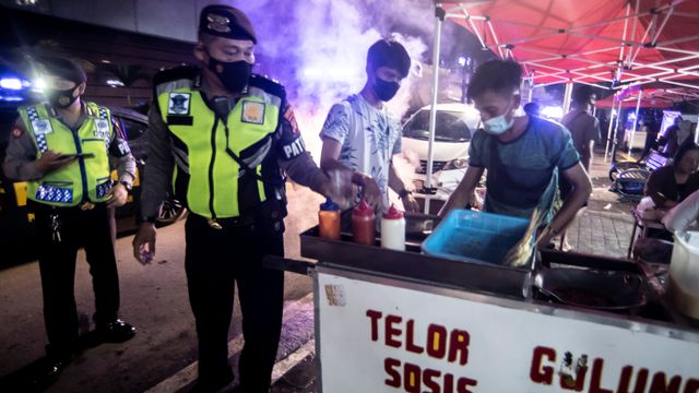 Petugas Satpol PP membubarkan aktivitas pedagang kaki lima di kawasan Bulungan, Jakarta, Senin (21/6/2021). Foto: Muhammad Adimaja/ANTARA FOTO