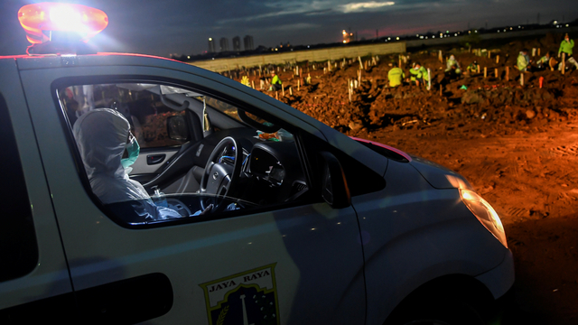 Petugas bersiap menurunkan jenazah yang akan dimakamkan dari dalam mobil ambulans di TPU Rorotan, Cilincing, Jakarta Utara, Senin (21/6/2021). Foto: M Risyal Hidayat/ANTARA FOTO