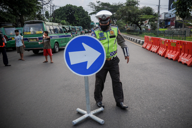 Polisi menaruh rambu lalu lintas saat penutupan akses jalan menuju Jalan Soekarno-Hatta di perbatasan antara Kabupaten Bandung dan Kota Bandung, Jawa Barat. Foto: Raisan Al Farisi/Antara Foto